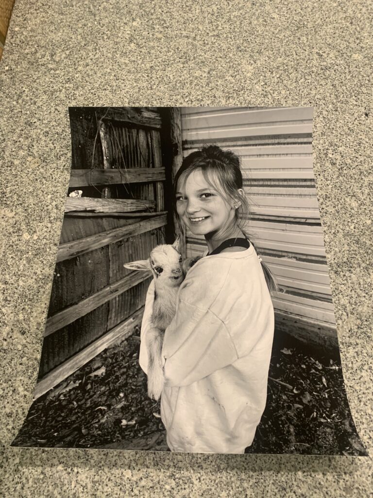 poster of my granddaughter holding a baby goat in black and white